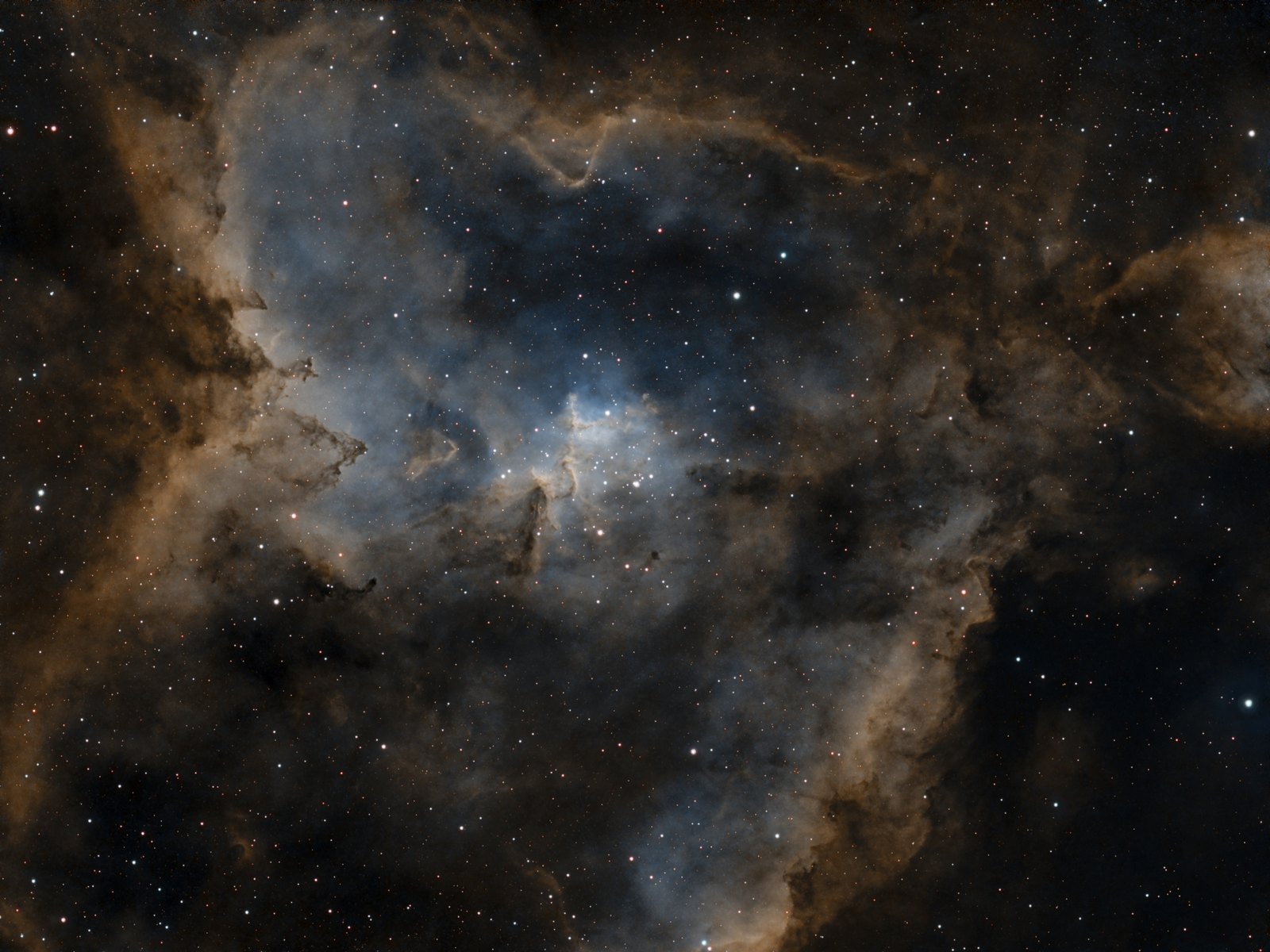 The Heart Nebula core processed in orange and blue: sharp pillars and a glowing blue centre